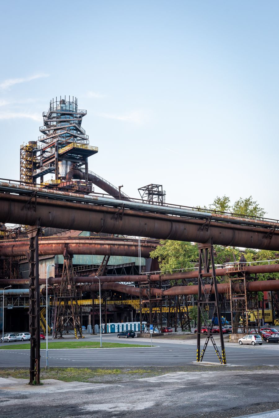 Industriální areál v Ostravě s rezavými potrubími a komíny