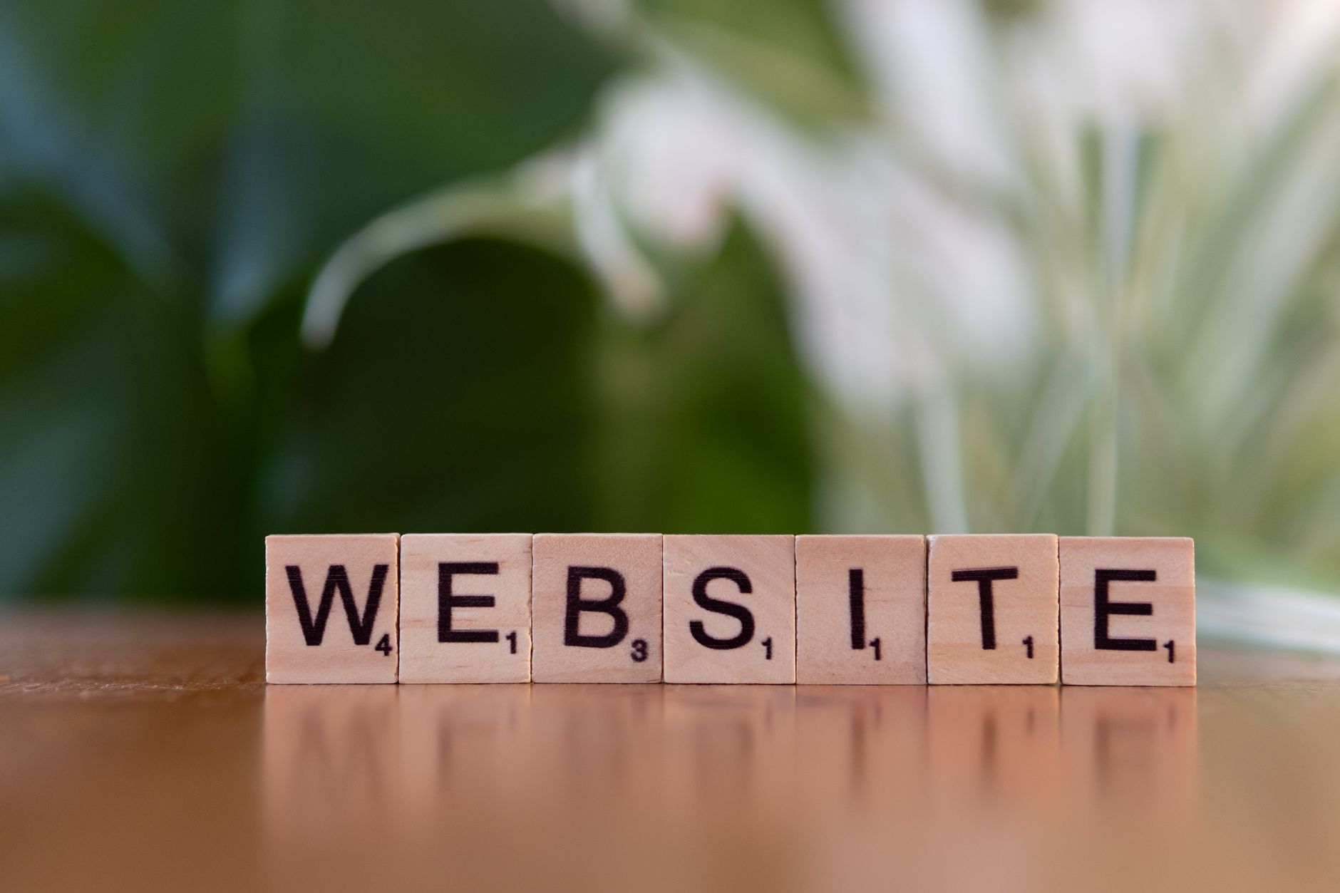 AI untuk optimasi website - Scrabble tiles on a wooden surface forming the word 'Website', symbolizing digital communication.