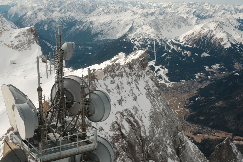A breathtaking aerial view of Zugspitze with a snow-covered landscape and communication tower.