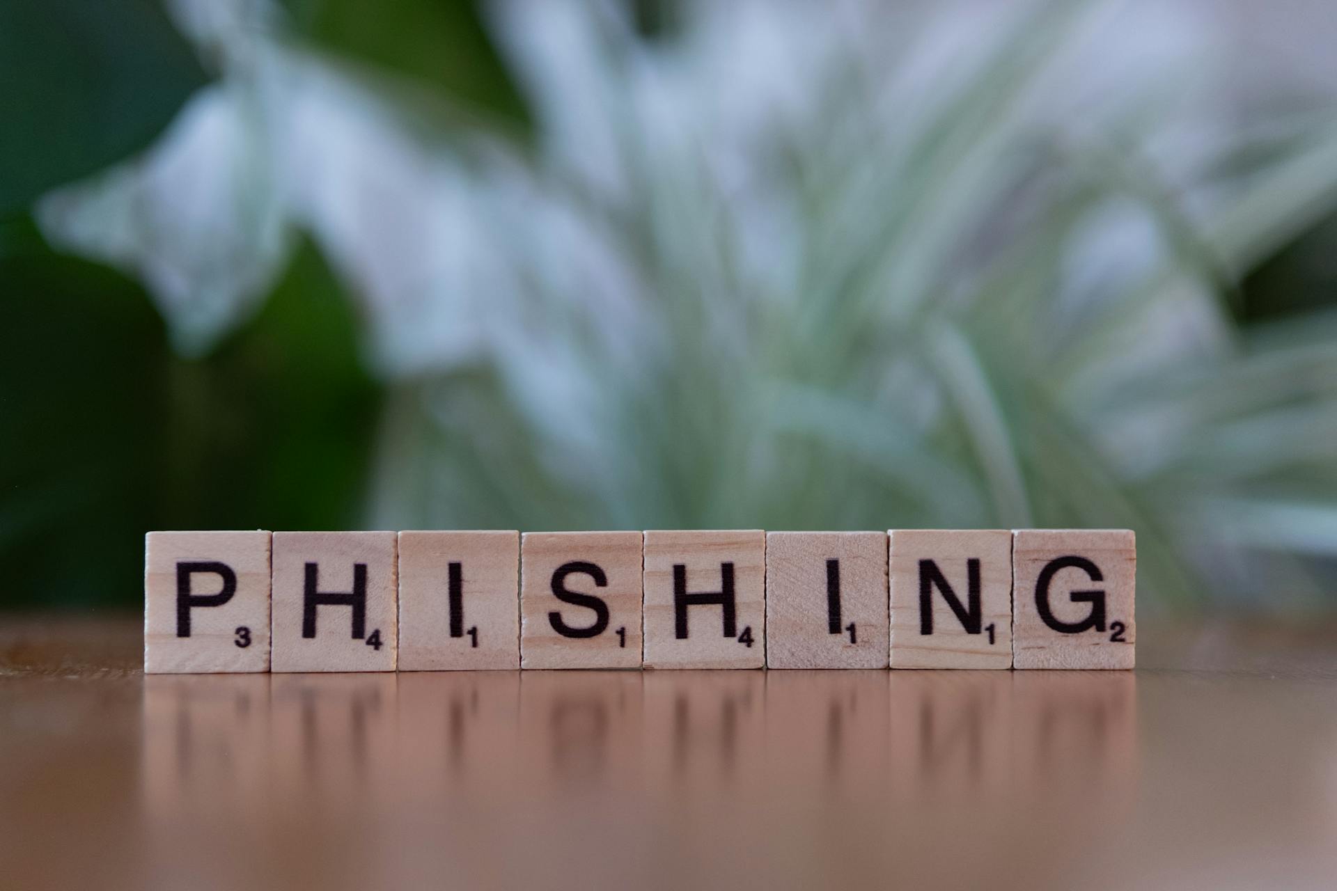 Wooden tiles spelling 'phishing' highlight cybersecurity themes.