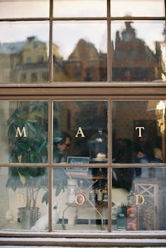 Charming window view of a cafe with vintage reflections and indoor plants.