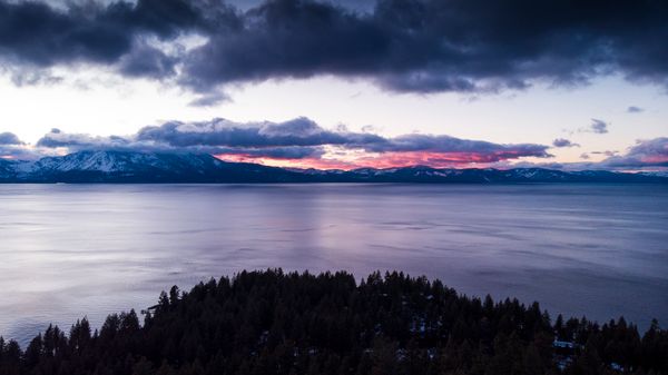 Aerial sunset view of Lake Tahoe with mountains and vibrant sky - perfect for family reunions