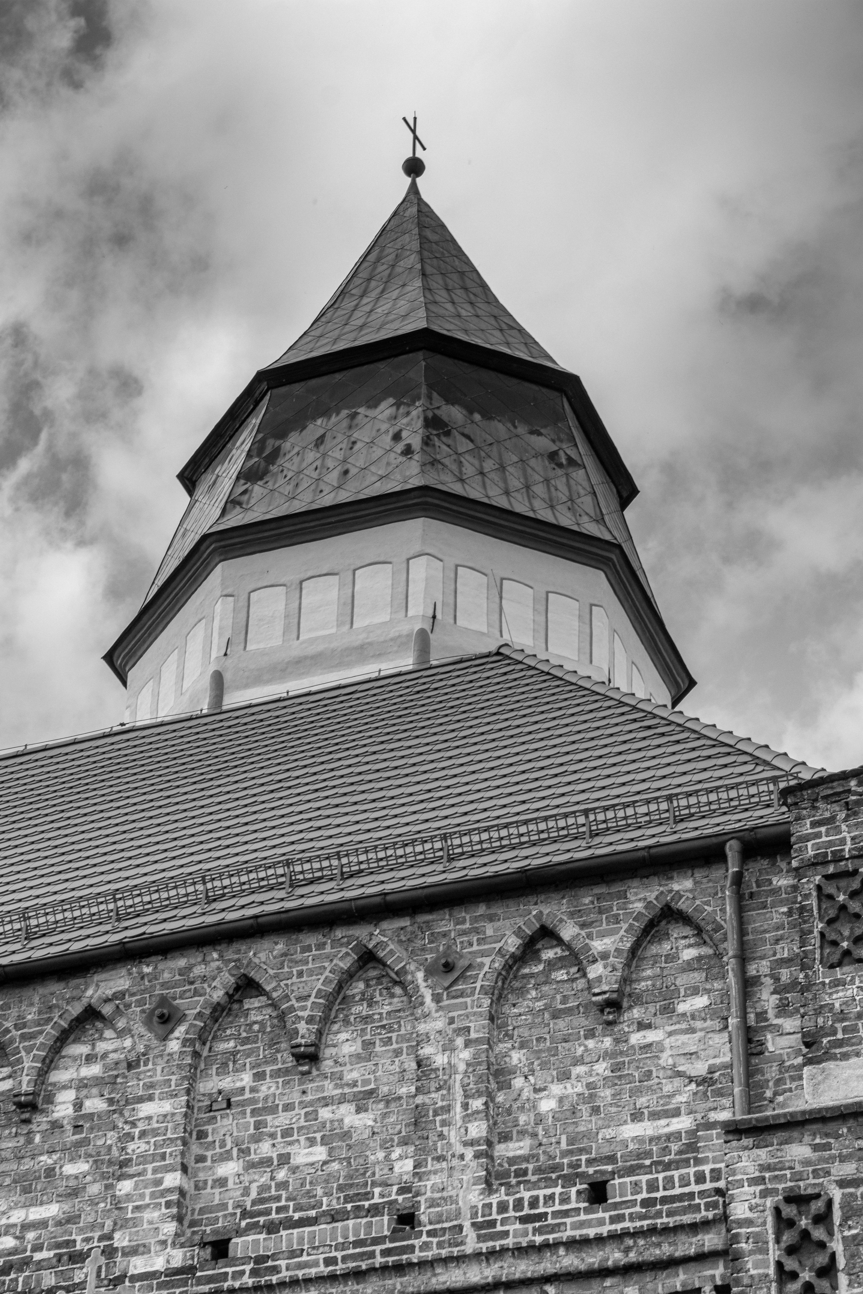 Black and white photo of a Gothic church tower in Kożuchów, Poland.