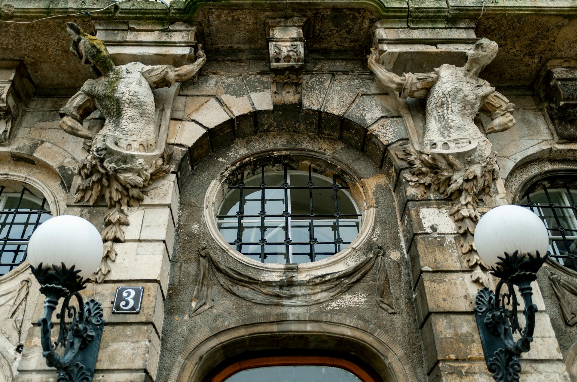 Detailed view of ornate sculptures adorning a historic building facade in Lviv, Ukraine.