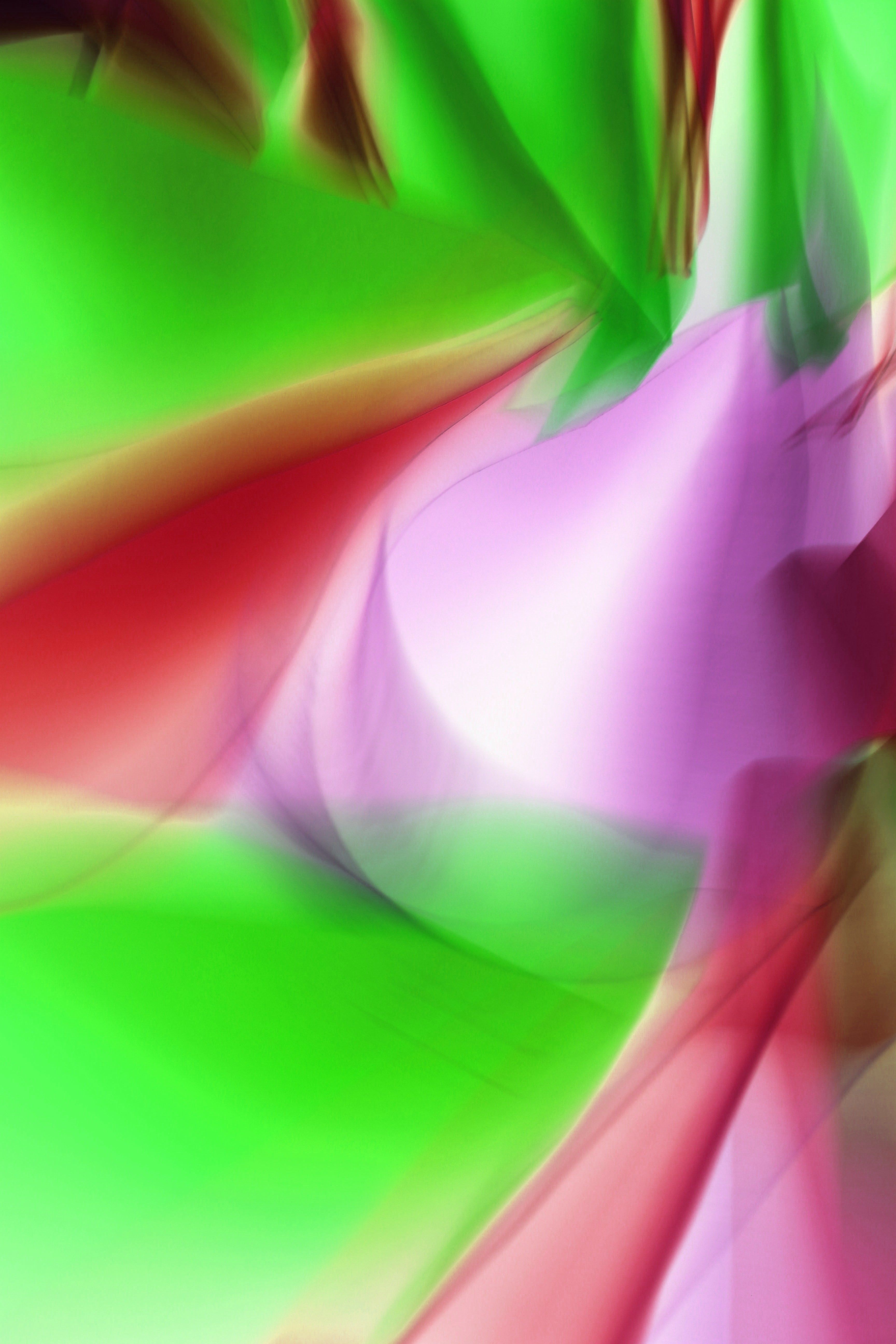 Vibrant abstract image with green, red, and purple light patterns creating a dynamic, fluid design.