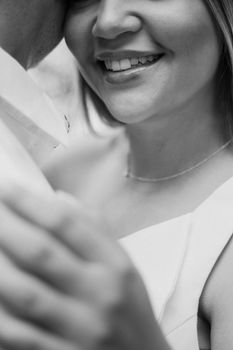 Black and white close-up of a happy couple embracing, highlighting joy and affection.