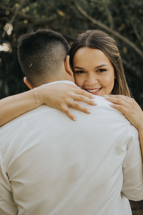 Free A woman embracing a partner with a smile in an outdoor setting. Stock Photo