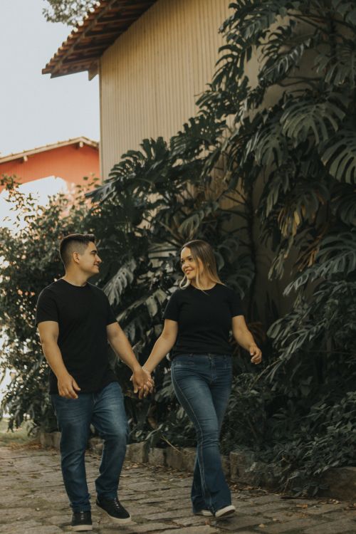Free Happy couple holding hands walking outside on a sunny day. Stock Photo