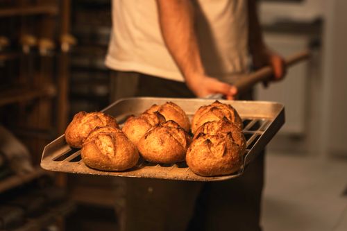 Free Close-up of freshly baked artisan bread in a bakery, exuding warmth and craftsmanship. Stock Photo