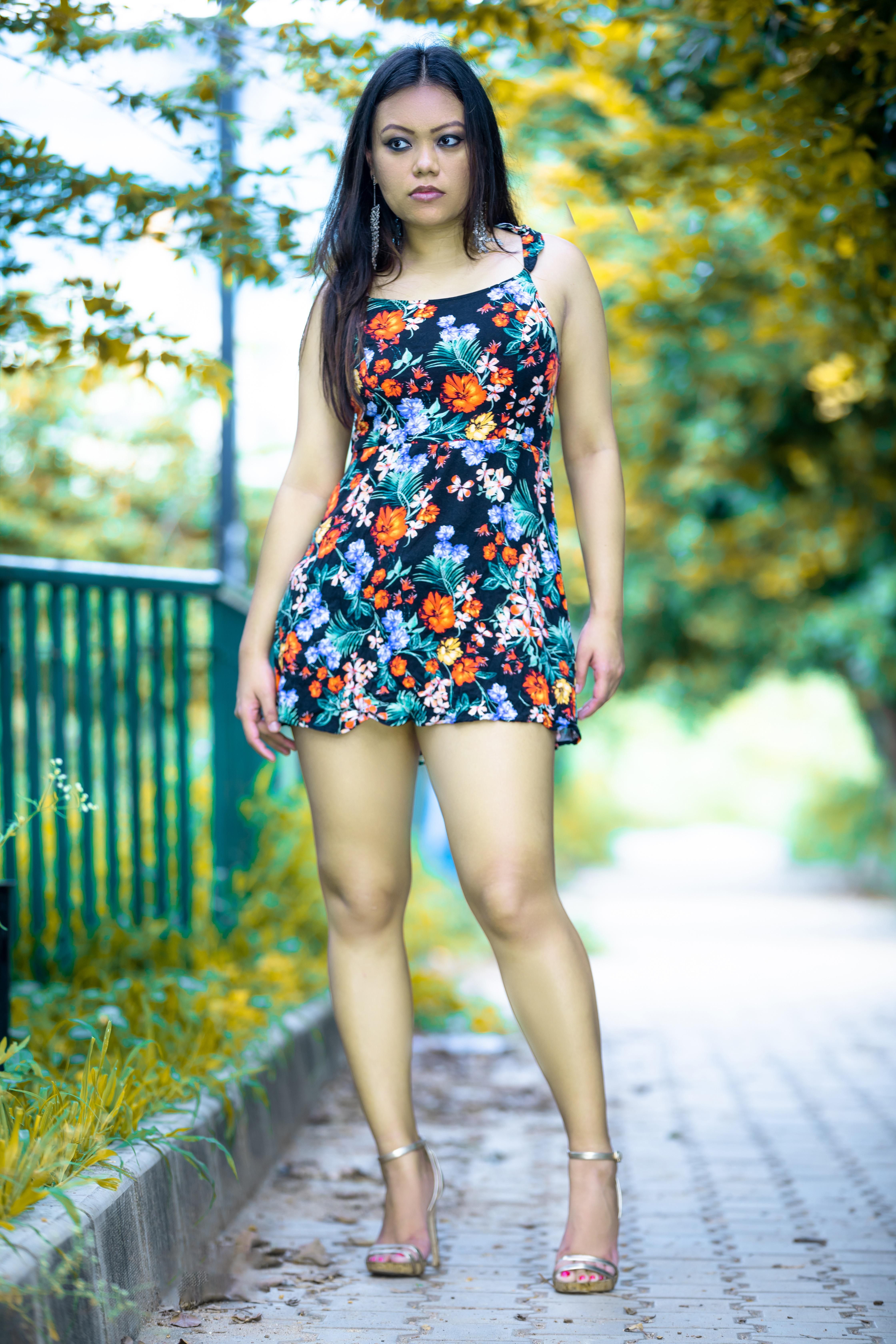 Stylish portrait of a woman in a floral dress walking outdoors in Bengaluru, India.