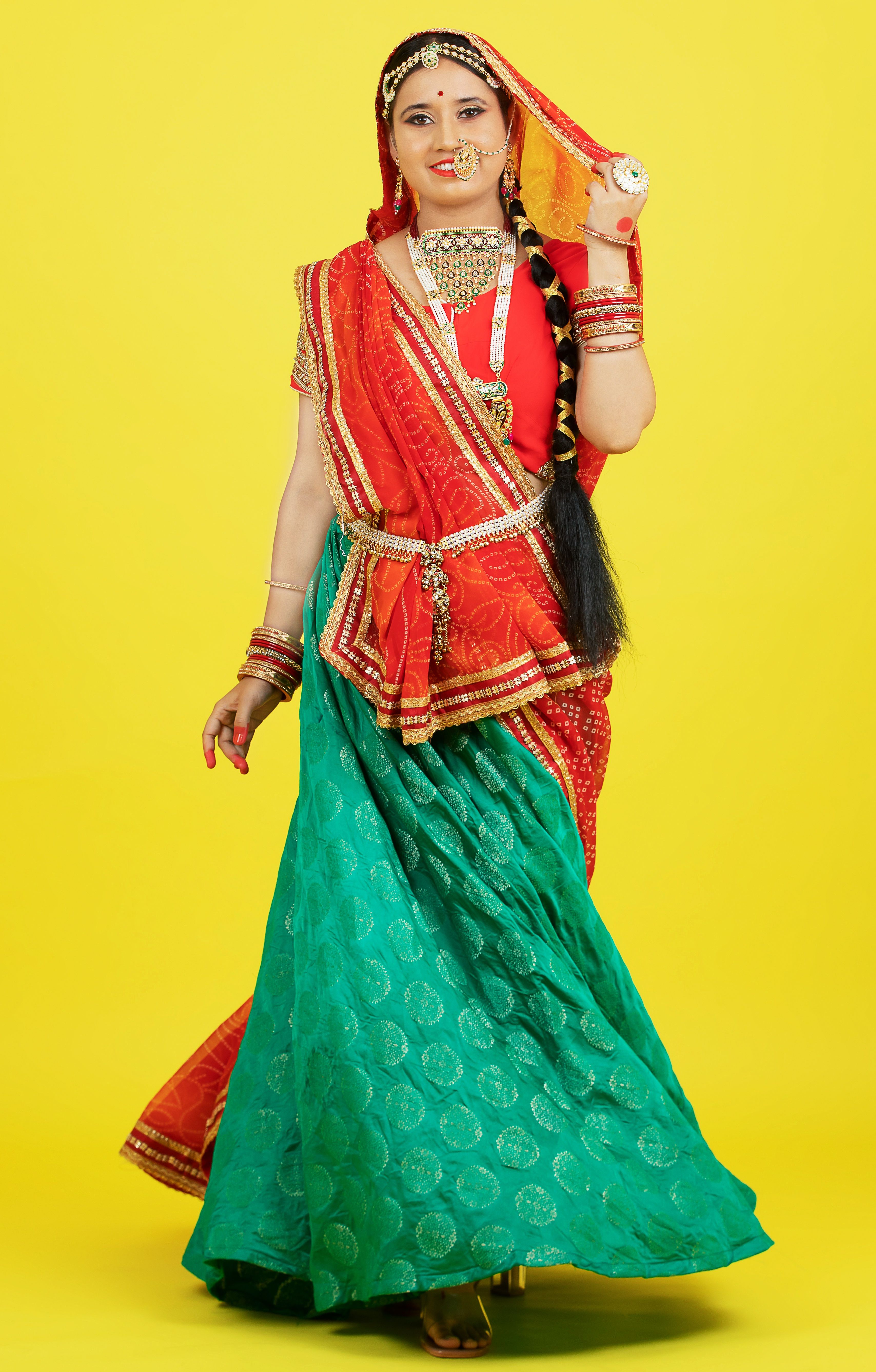 Portrait of an Indian woman wearing vibrant Rajasthani traditional clothing with jewelry.
