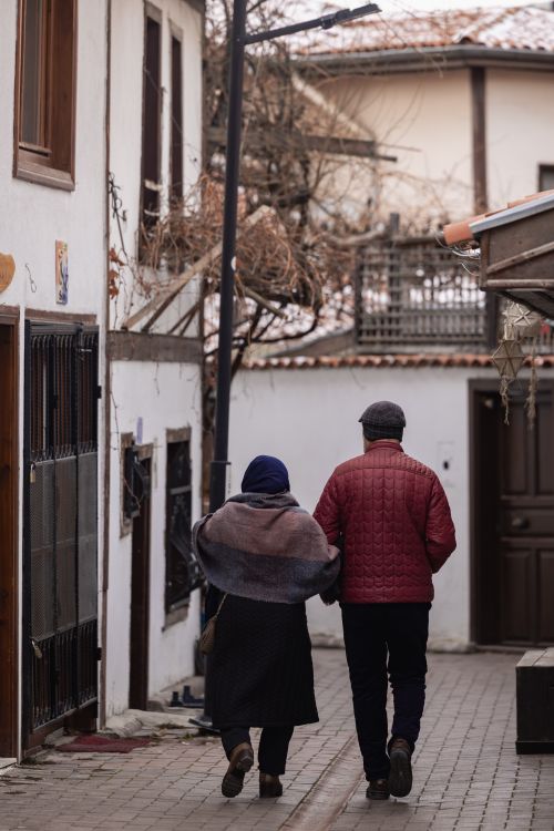 Free A couple walks hand in hand on a charming street in Ankara, showcasing love and winter style. Stock Photo