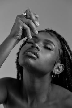 A captivating black and white portrait of a woman with an expressive pose and braided hair.