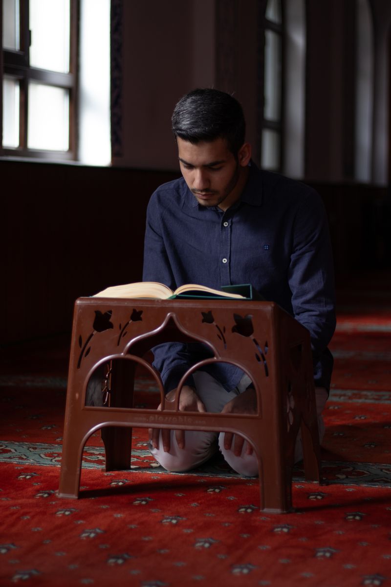 A man reading the Qur'an from a wooden bookstand