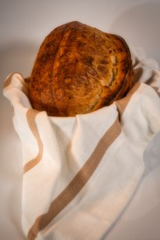 Delicious freshly baked artisan bread wrapped in a white cloth, showcasing a rustic look.