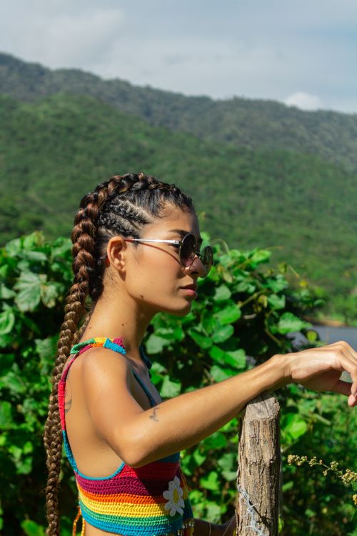 Free Portrait of a woman with braided hair in a vibrant outfit surrounded by lush nature in Brazil. Stock Photo