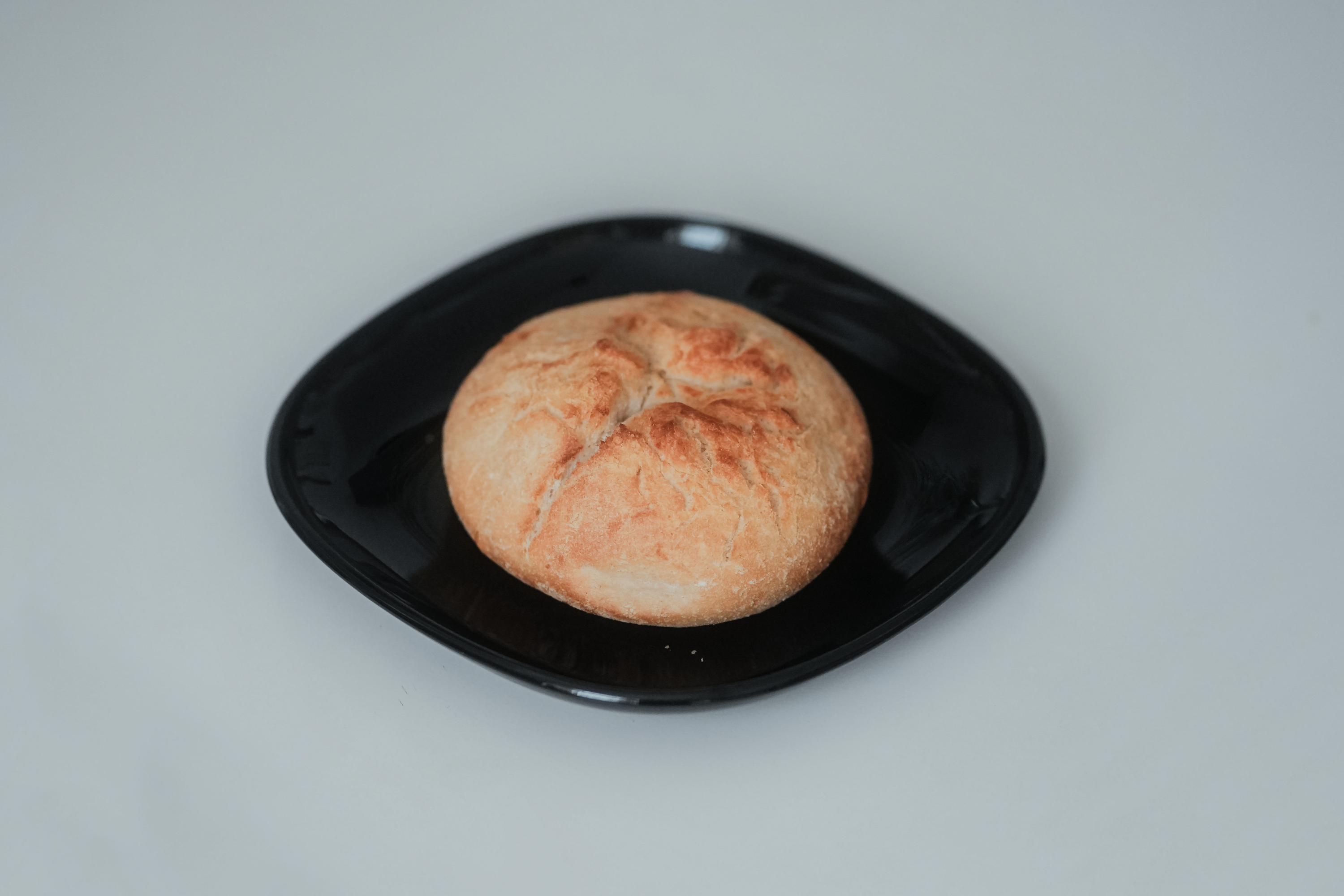 Golden Dutch crunch rolls with a deeply cracked, tiger-striped crust arranged on a wire cooling rack.