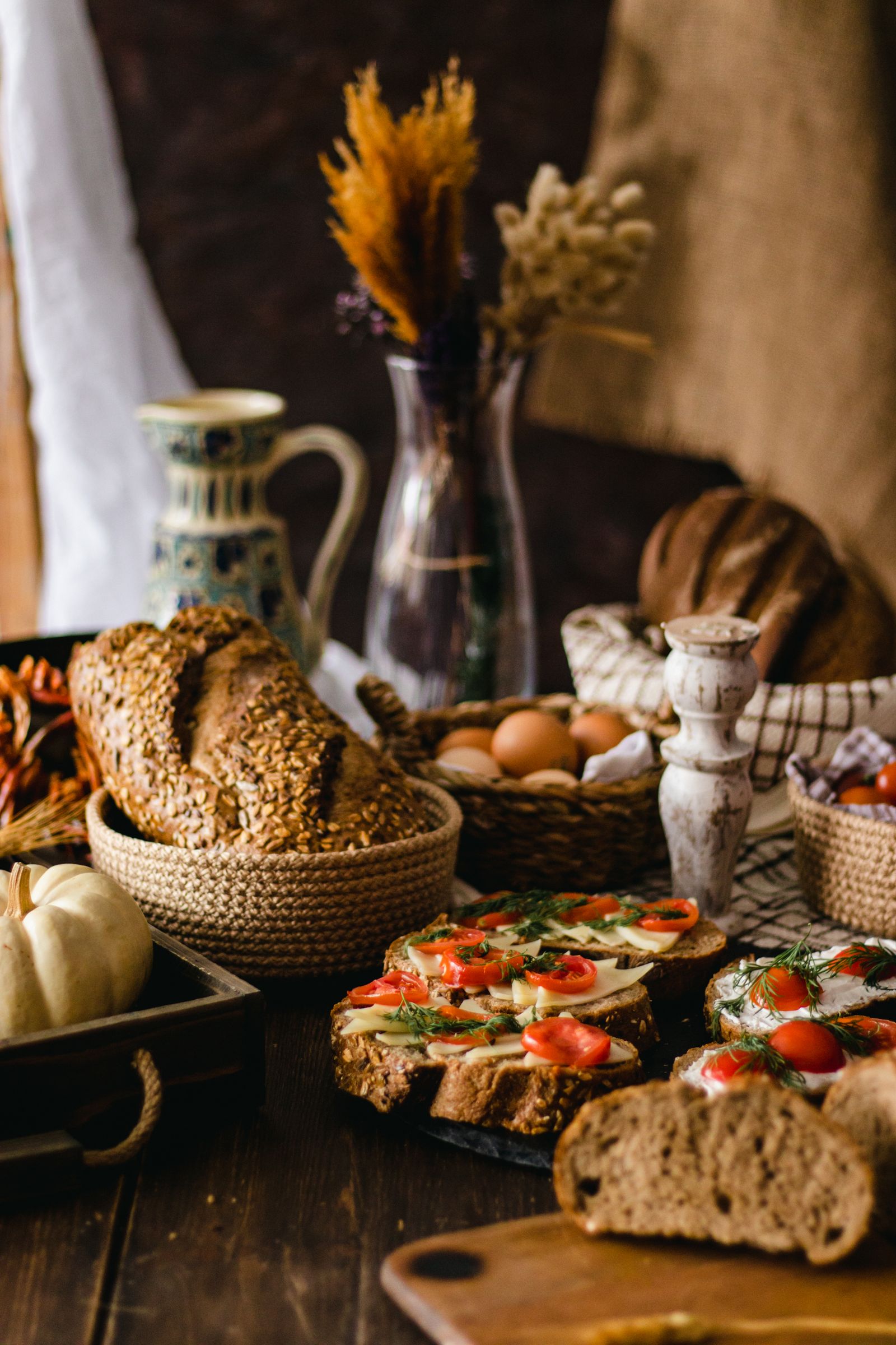 Rustic bread, vegetables and flowers arranged on a table