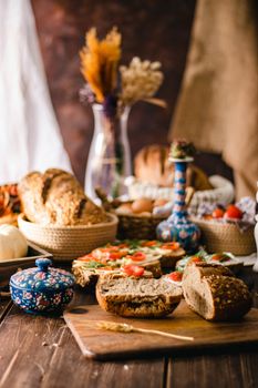 Delicious rustic bread on a wooden table with fresh ingredients, creating a cozy and inviting setting.