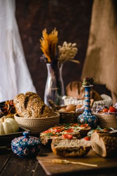 A rustic display of breads, cherry tomatoes, and decorative elements exuding a warm, cozy atmosphere.