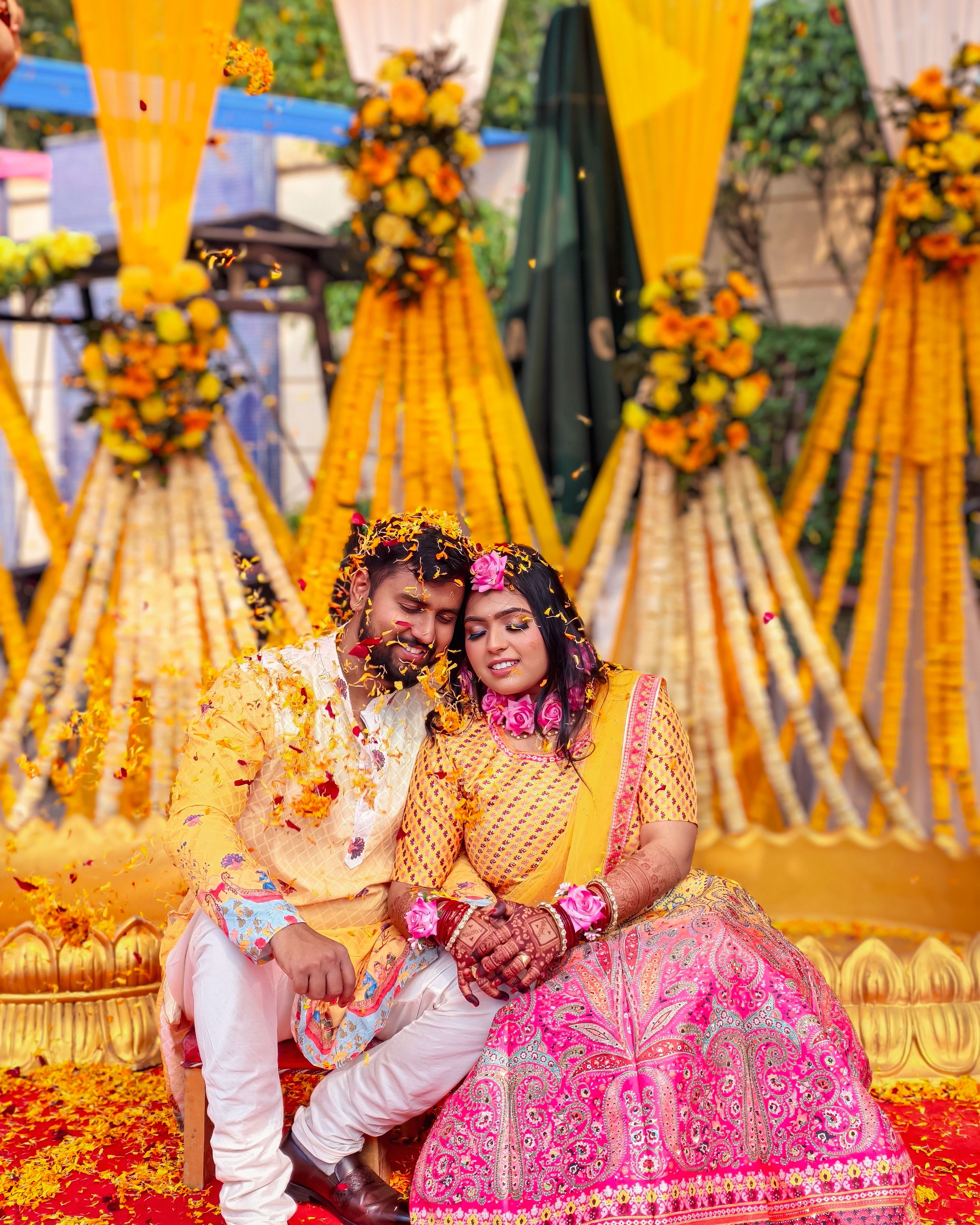 Colorful Indian couple enjoying a traditional wedding with floral decorations.