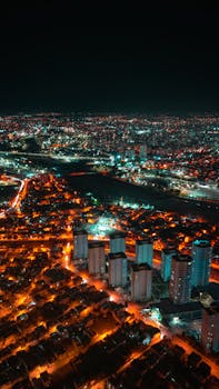 A breathtaking aerial view of a vibrant cityscape at night with illuminated buildings.