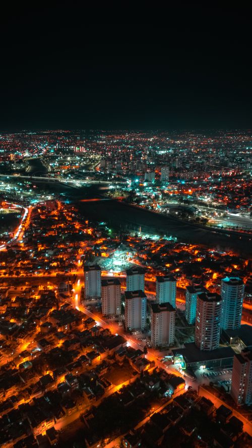 Free A breathtaking aerial view of a vibrant cityscape at night with illuminated buildings. Stock Photo