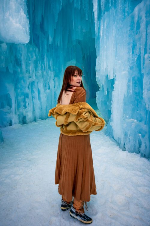 Free Model in winter attire poses in an ice cave at Cripple Creek, Colorado, showcasing style against nature's backdrop. Stock Photo