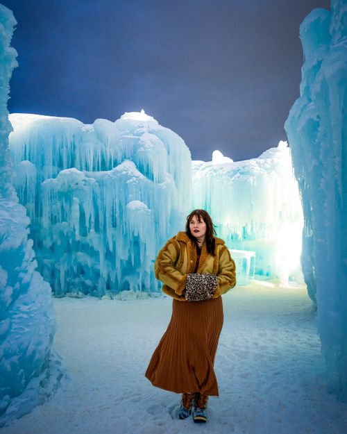 Free Elegant winter fashion portrait in a breathtaking ice castle setting, perfect for travel and fashion themes. Stock Photo