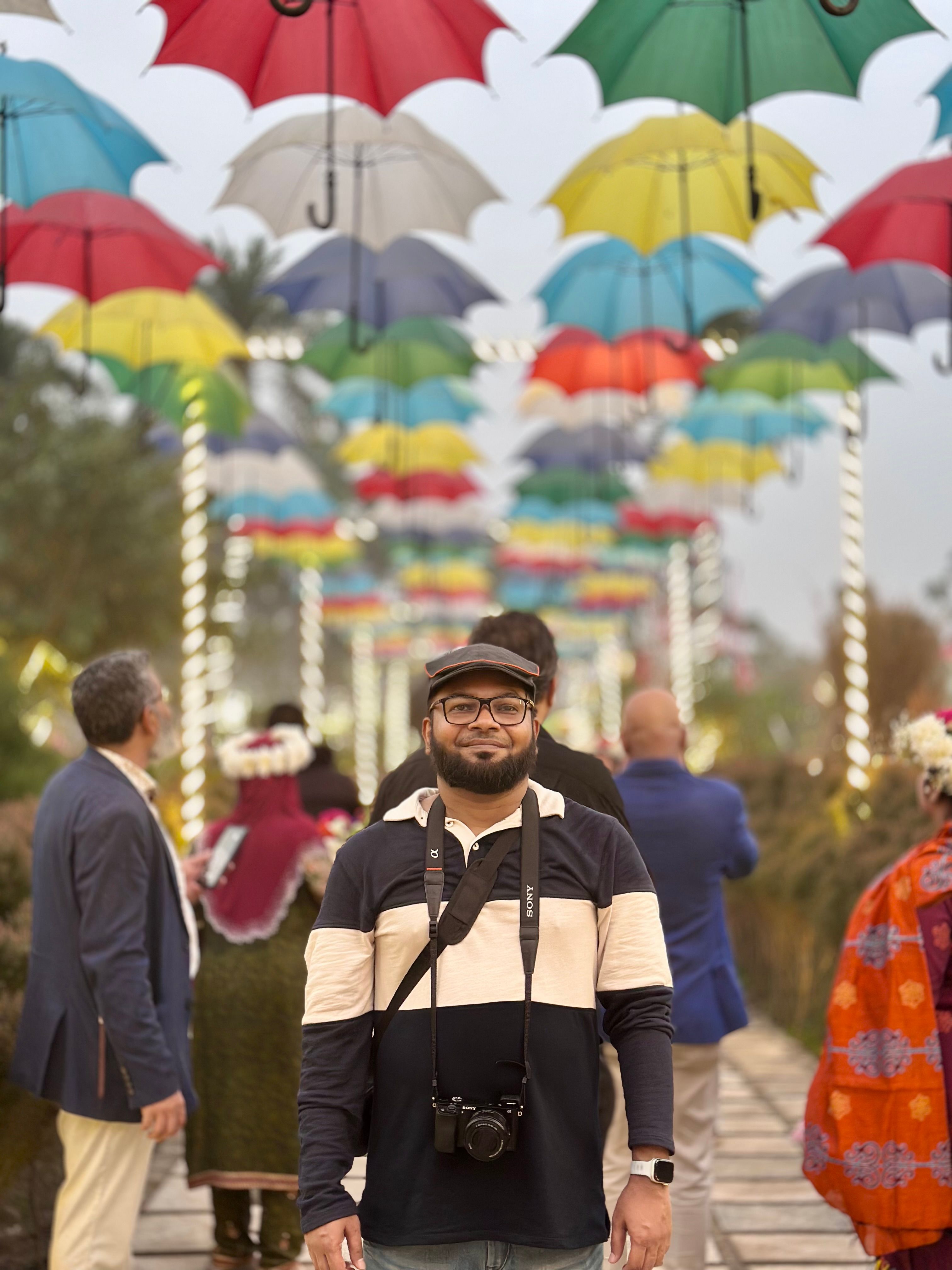 Vibrant pathway adorned with colorful umbrellas and people enjoying the display.