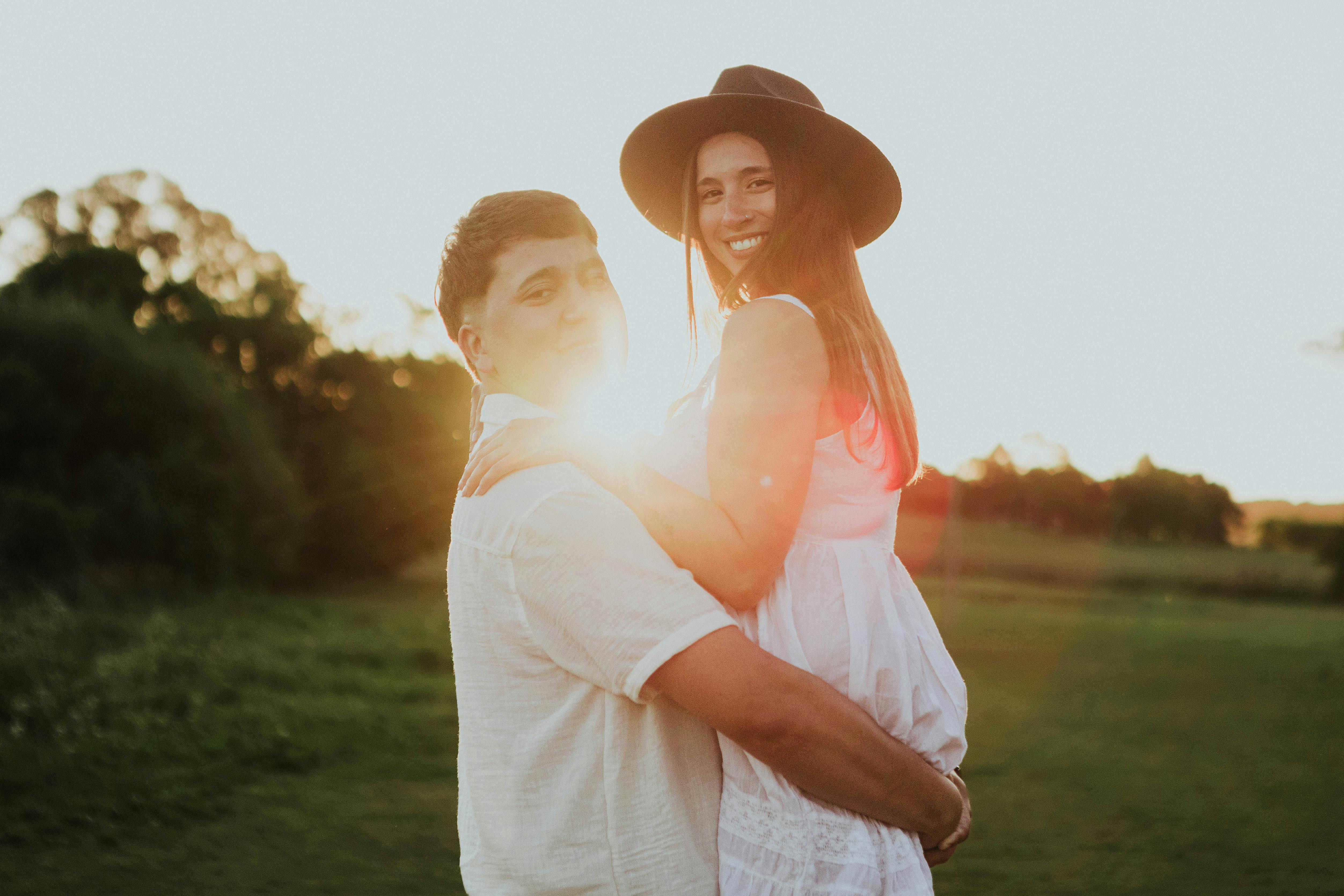 Young couple enjoying a romantic moment outdoors at sunset, showcasing love and happiness.
