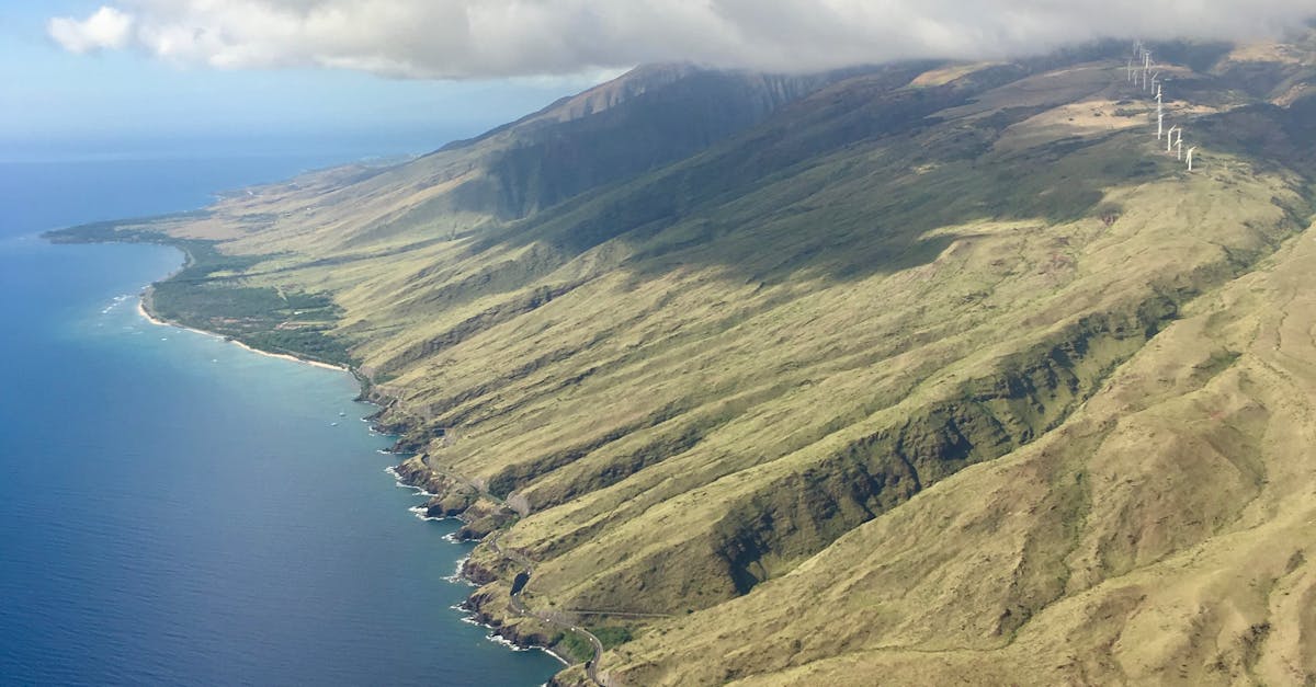 Photo by Pred Sek Stunning aerial view of Maui's dramatic coastline under a blue sky with clouds.