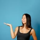 Confident woman gesturing against blue background