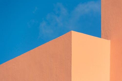 Free Simple ocher walls create a minimalist design against a bright blue sky. Stock Photo