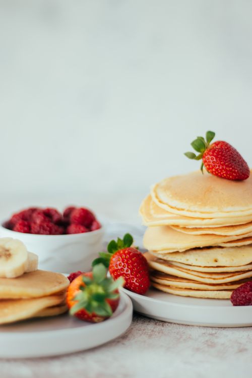 Free Appetizing pancakes stacked with strawberries and bananas, perfect breakfast scene. Stock Photo