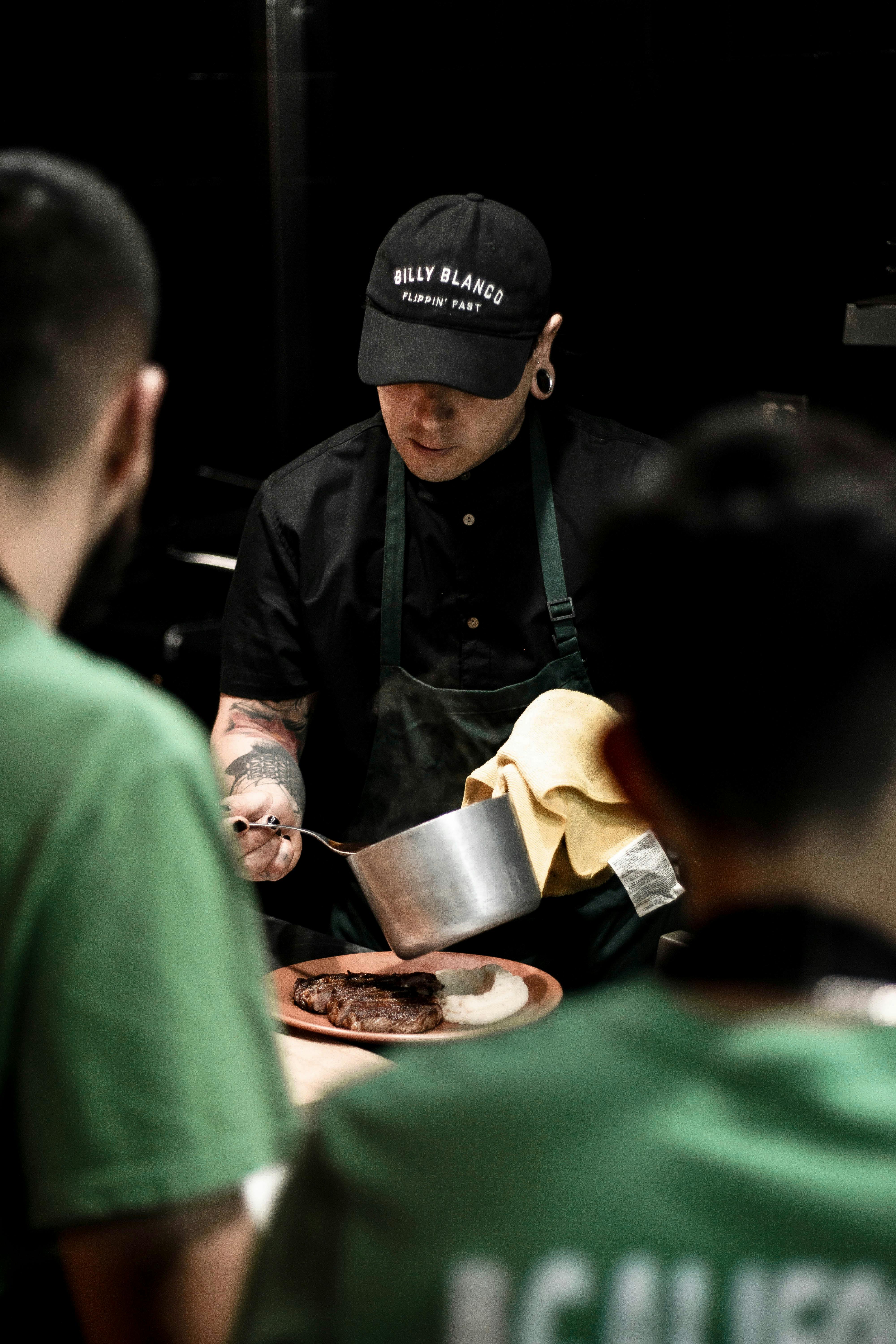 Chef in a professional kitchen preparing a gourmet dish with focused attention.