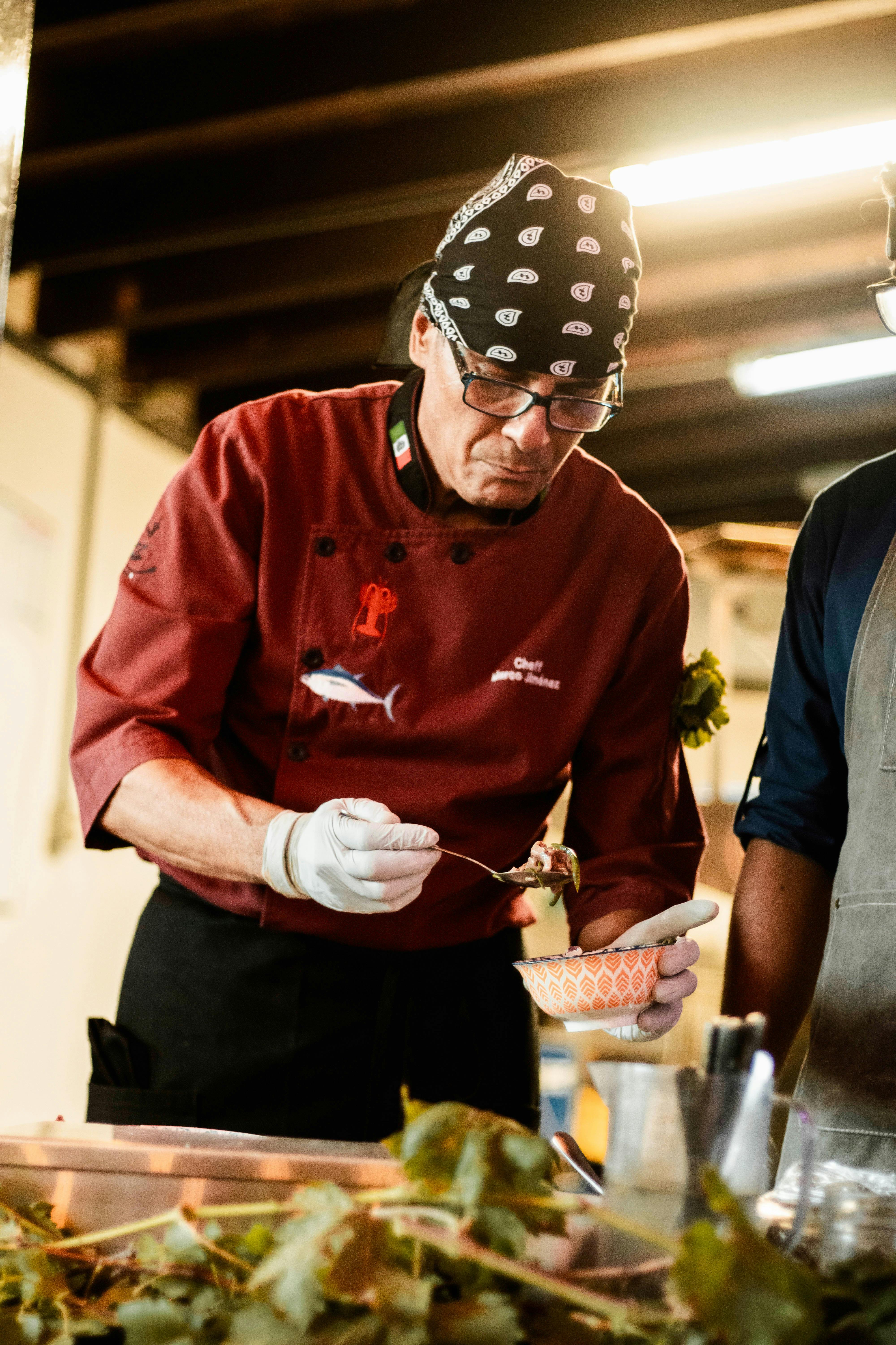 Chef preparing dish with precision in a restaurant kitchen setting.