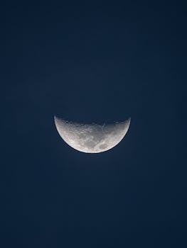 Serene crescent moon visible in the dark night sky, capturing lunar beauty.