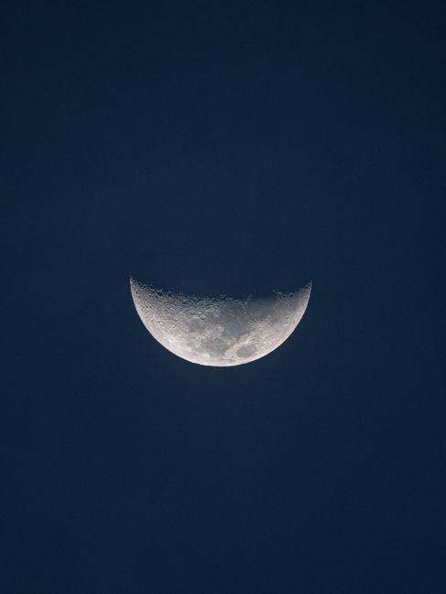 Serene crescent moon visible in the dark night sky, capturing lunar beauty.