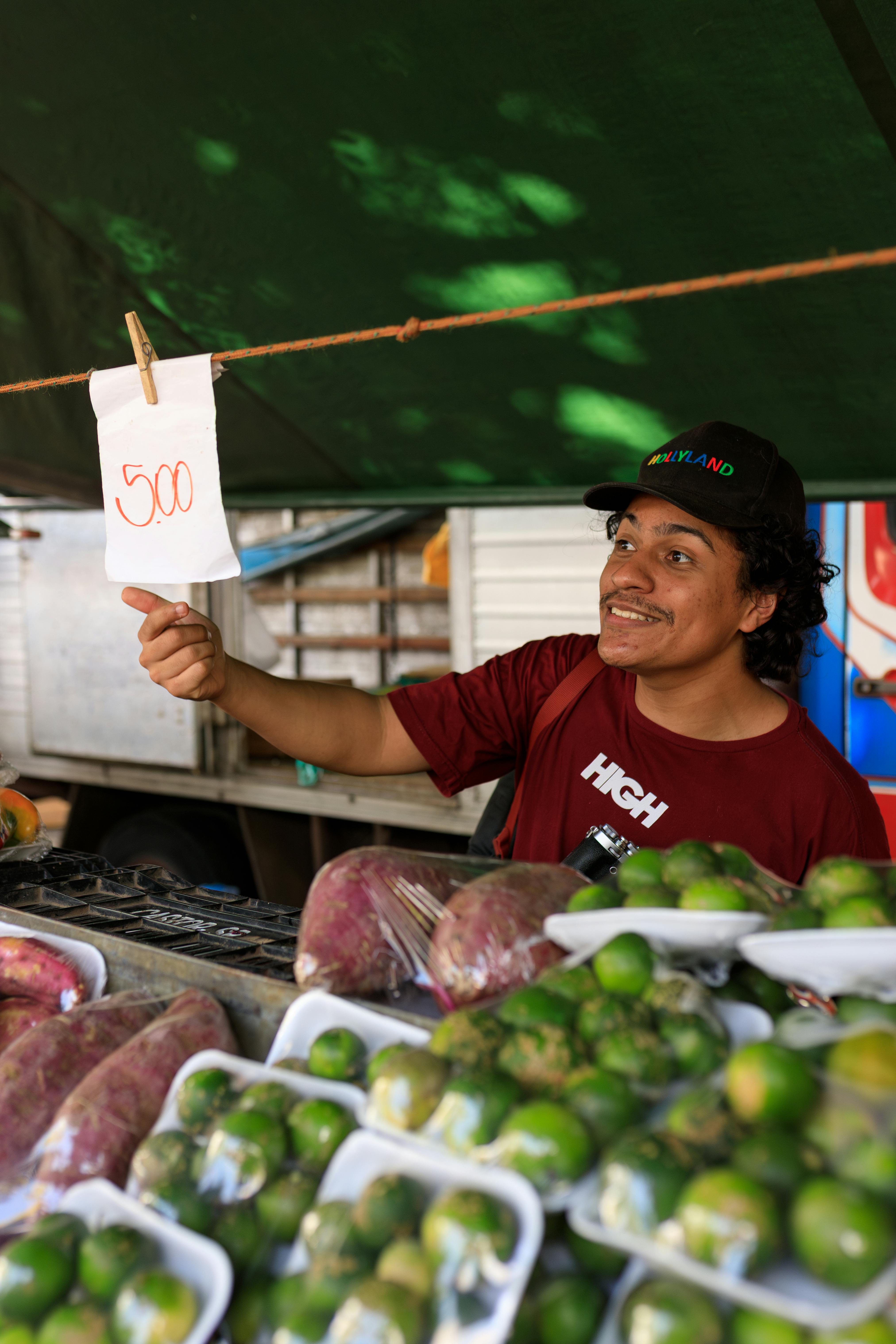 A cheerful vendor selling fresh fruits at a lively outdoor market.
