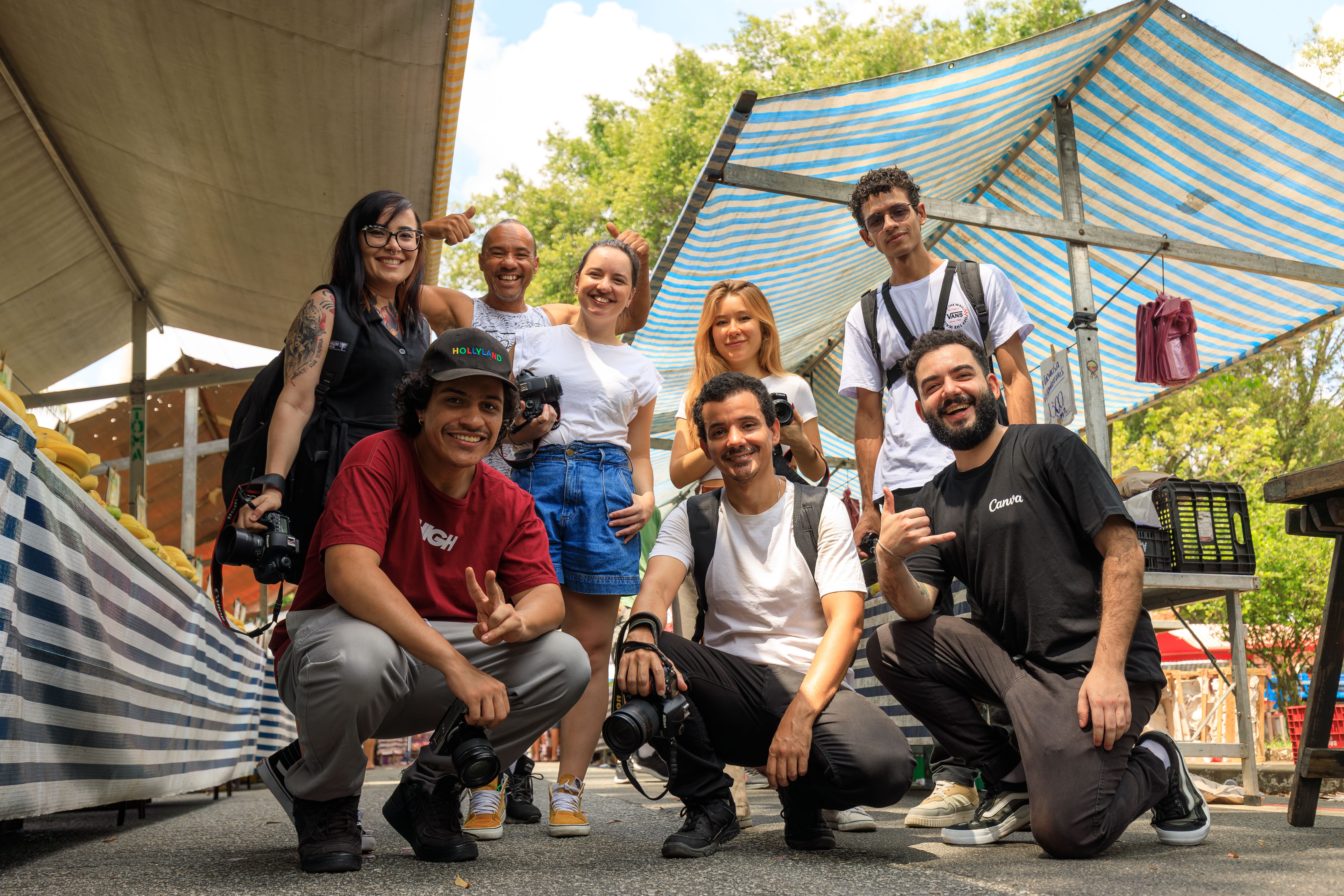 De franc Un grup divers de fotògrafs posant junts en un mercat a l'aire lliure en un dia assolellat. Foto d'estoc