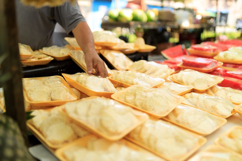 A person picking fresh packaged food at an outdoor market.