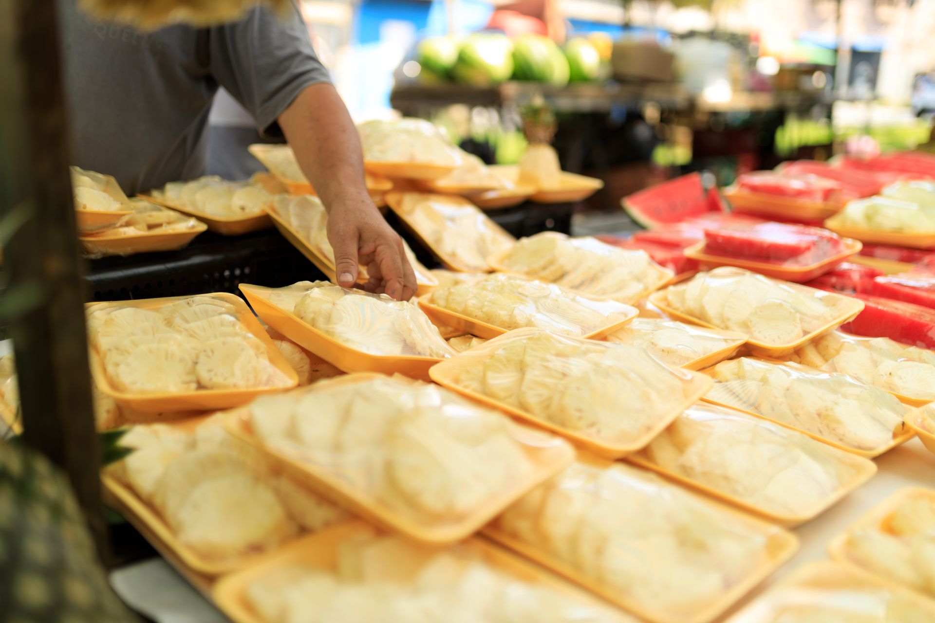 A person picking fresh packaged food at an outdoor market.