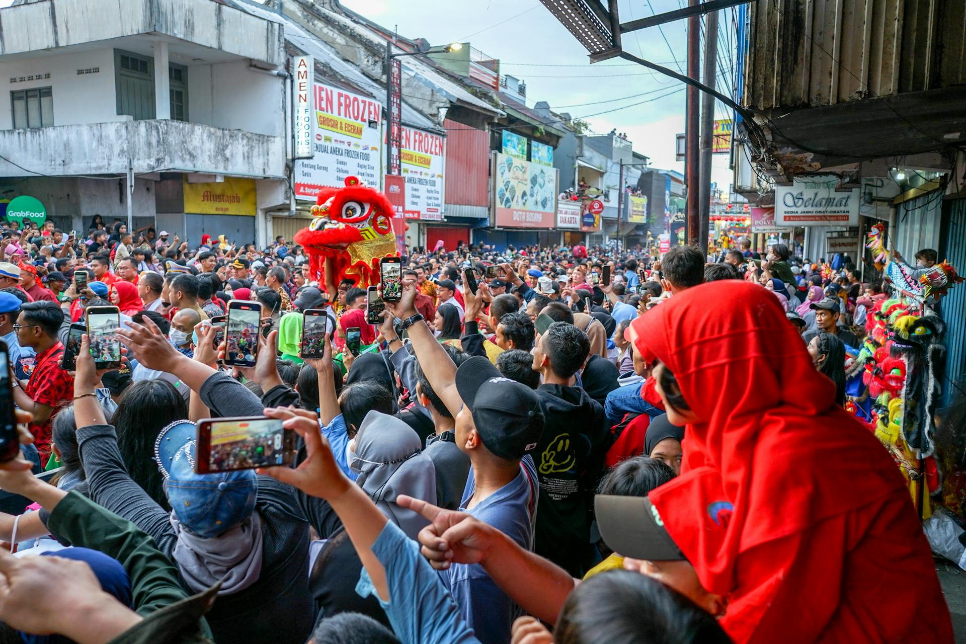 A lively crowd gathers for a colorful lion dance festival in West Java, Indonesia.