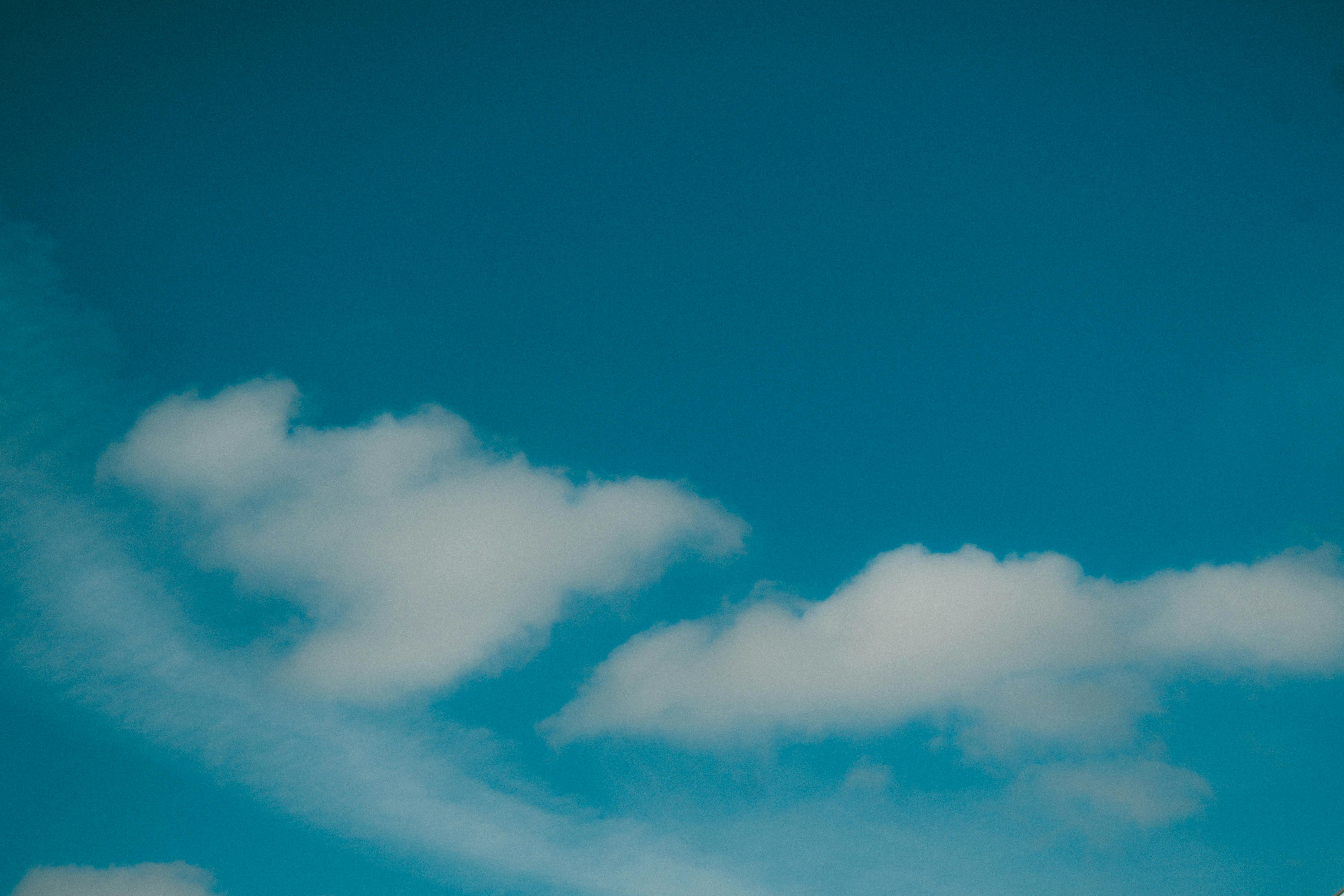 Free Vivid blue sky featuring soft, fluffy clouds on a sunny day. Stock Photo