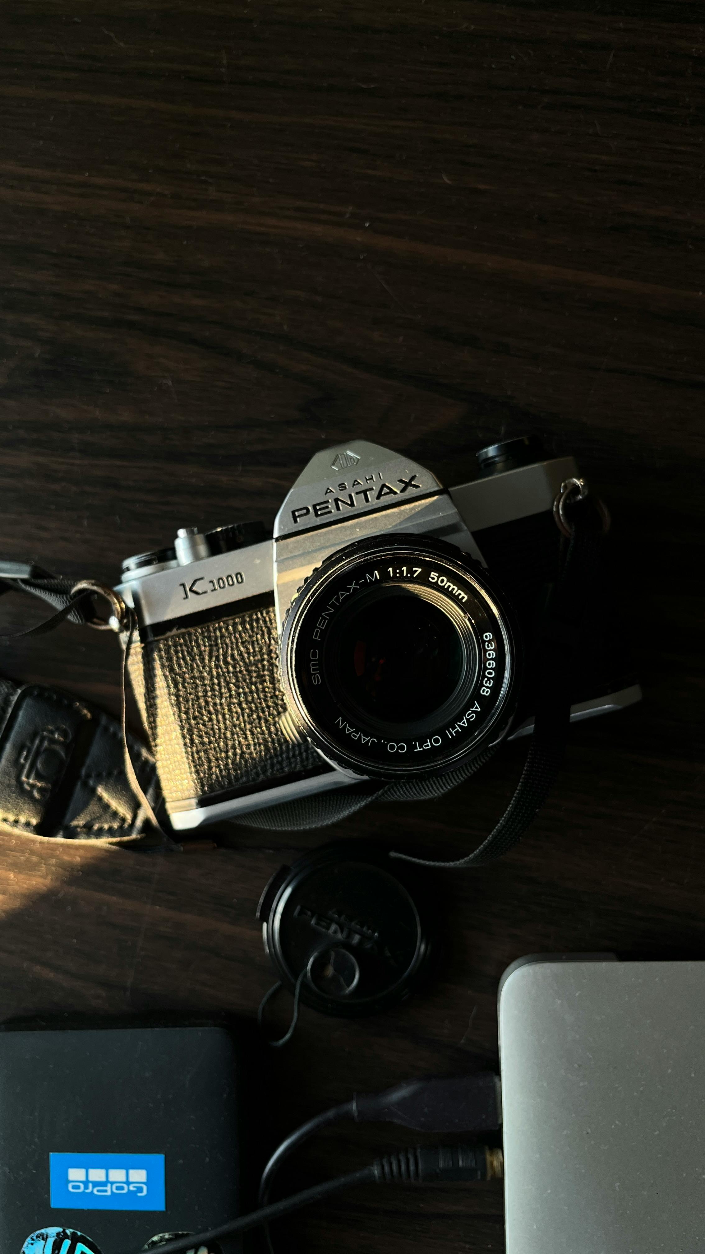 Δωρεάν Κλασική κάμερα Pentax που στηρίζεται σε ξύλινη επιφάνεια με ζεστή, vintage αίσθηση. Φωτογραφία από στοκ φωτογραφιών