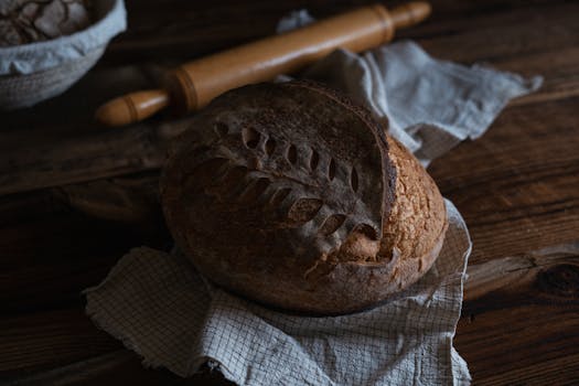 Artisan sourdough bread on cloth, with rustic wooden table setting.