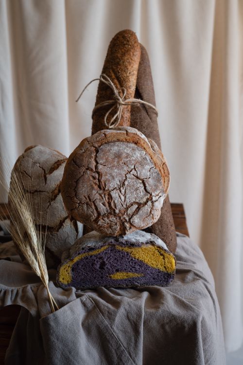 Free A collection of artisan bread with rustic textures in a cozy indoor setting, perfect for bakery promotions. Stock Photo
