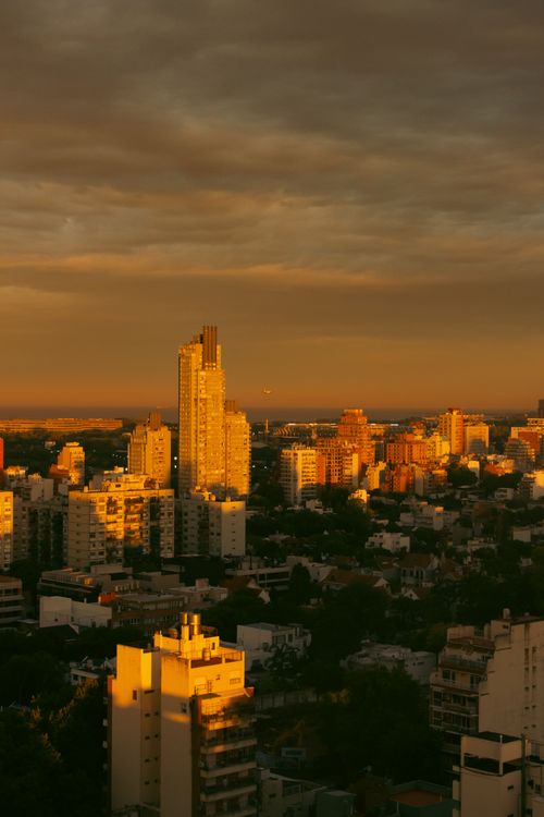 Free A scenic urban skyline at sunset with warm golden lighting and tall buildings. Stock Photo
