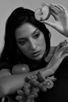 Artistic black and white portrait featuring a woman with various fruits.